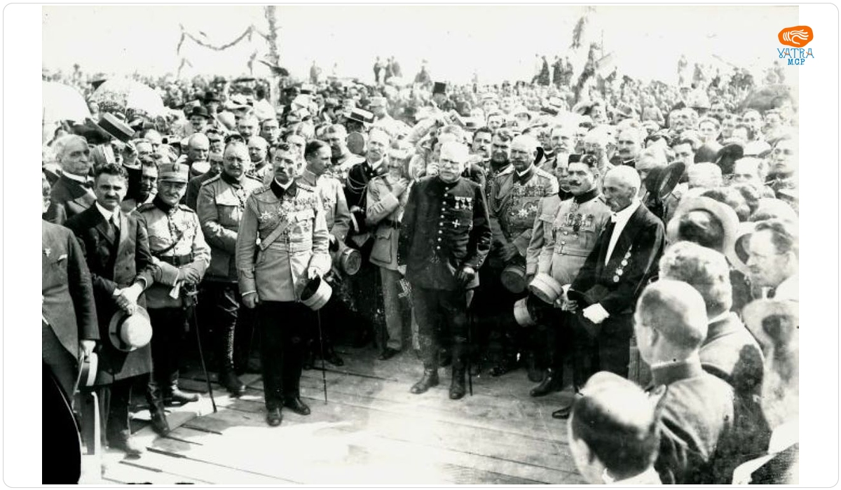 Grup de militari și câțiva civili cu capetele descoperite, ascultând citirea proclamației