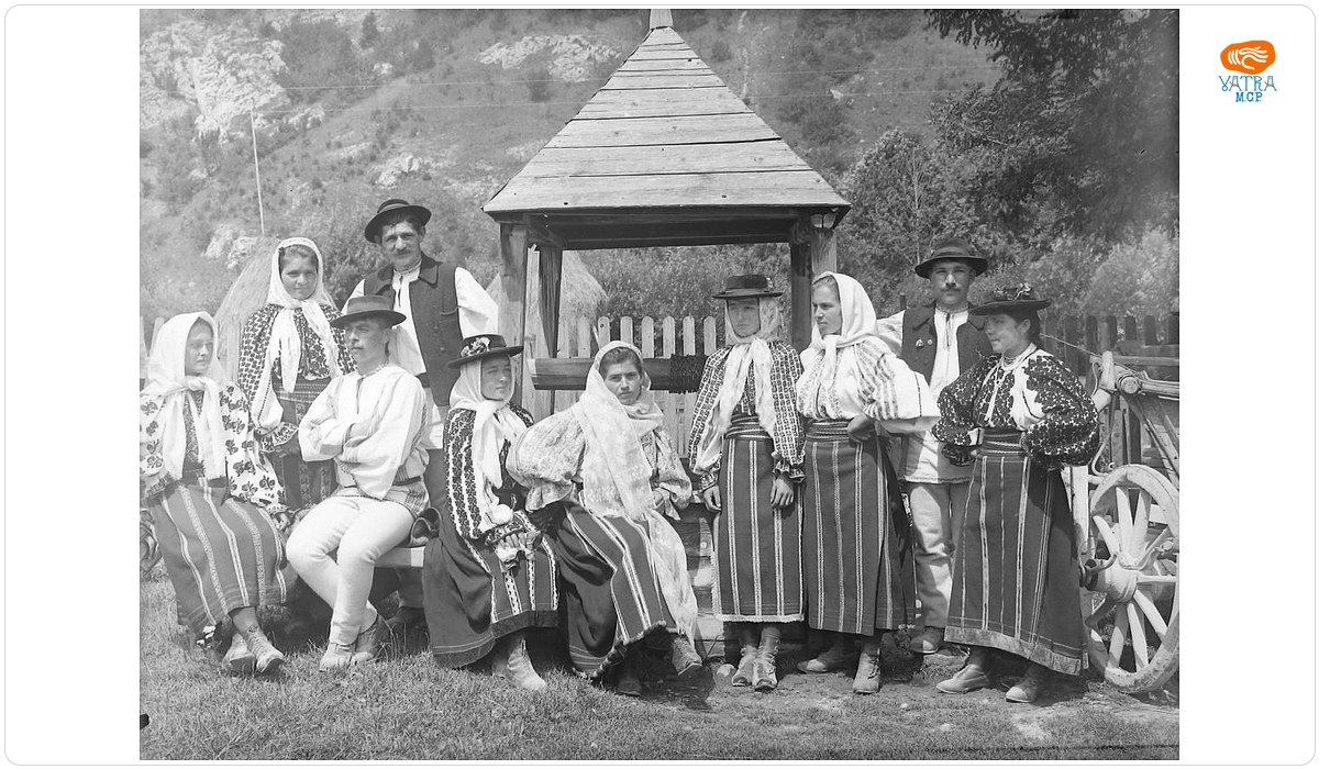 Grup de țărani în port popular lângă fântână